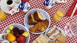 A breakfast table with a variety of foods and drinks, including bread, fruits, and dairy products. - B&B La cascata (Noci)