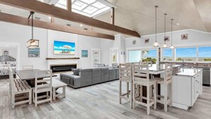 A spacious living area with a large sofa, a dining table, and a kitchen island. - Bumpa's Big House - Bring the Grandkids! (Marathon)