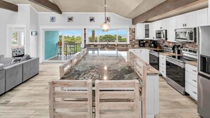 A spacious kitchen with a large island, white cabinetry, and stainless steel appliances.