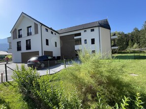 Un bâtiment moderne à deux étages, avec une voiture garée devant.