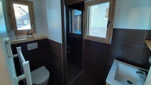 Ein Badezimmer mit Toilette, Waschbecken und Duschbereich.