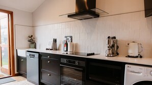 Una cocina moderna con lavavajillas, horno y cafetera.