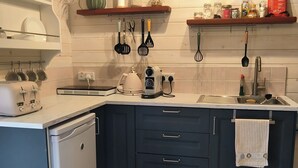 Una cocina moderna con armarios blancos, lavavajillas integrado y piso de madera.
