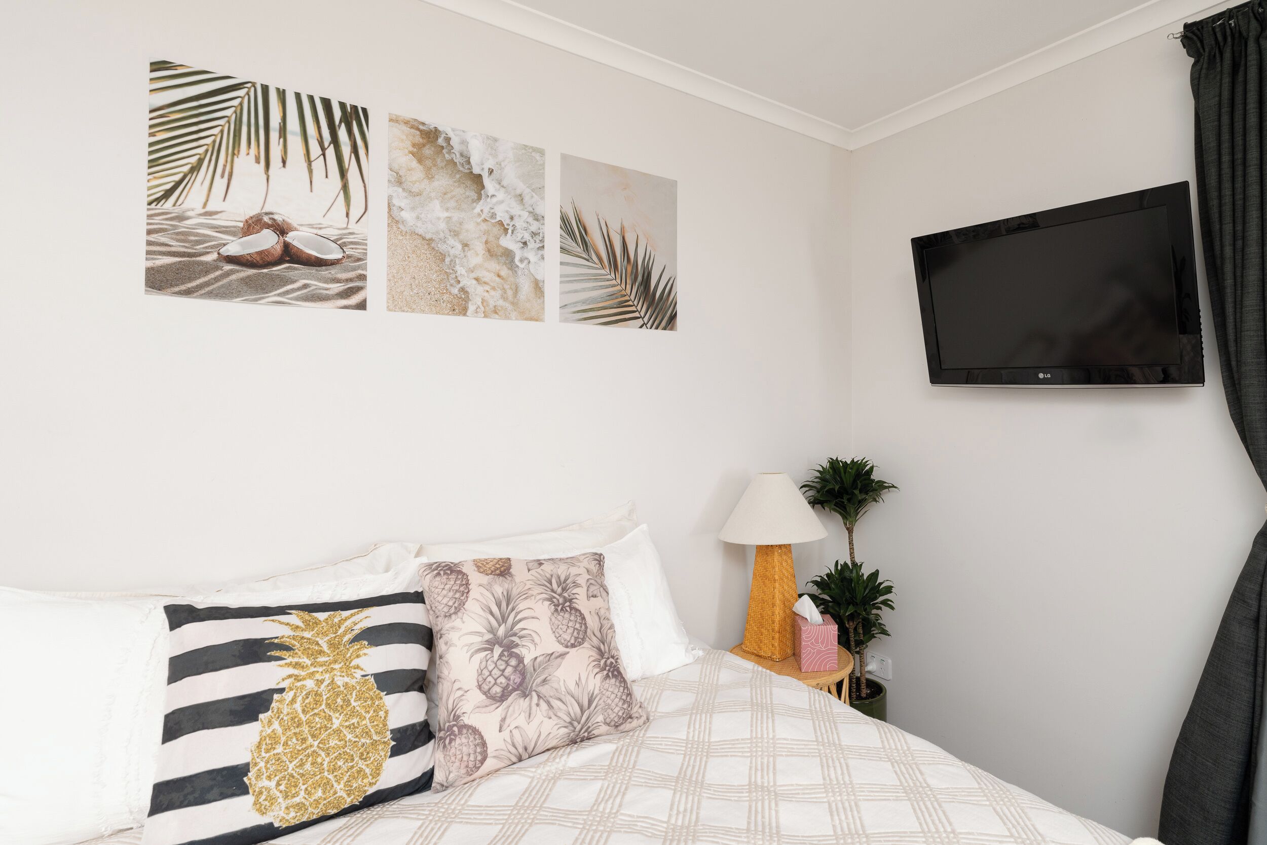 Una camera da letto con un letto, una televisione, una lampada e decorazioni alle pareti.