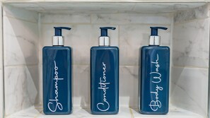 Three bottles of body wash in a bathroom shelf. - Stylish One Bedroom Flat in Kensingston, London (London)