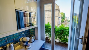A kitchen with a Bosch coffee maker, a toaster, and a kettle on the counter. - Stylish One Bedroom Flat in Kensingston, London (London)