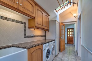 Laundry room with a washing machine and cabinetry, offering a convenient space for laundry needs.