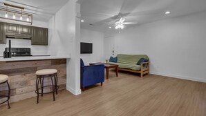 A modern kitchen with a bar area, a dining table with chairs, and a sofa in a living area. - Condo near downtown Austin, close to Town Lake! (Austin)