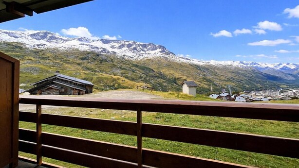 Vista de la montaña con un edificio de madera y una construcción pequeña al frente.