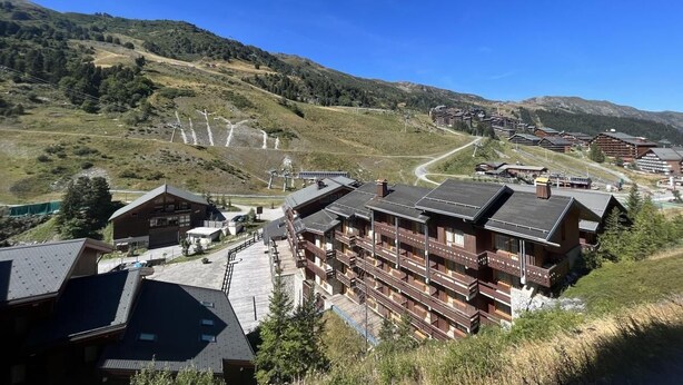 A mountain lodge with multiple balconies and a ski lift in the background. - 130m from ski slopes, 8th floor, view ski slopes, balcony, ski locker, 33m², Méribel-Mottaret (Méribel - Les Allues)