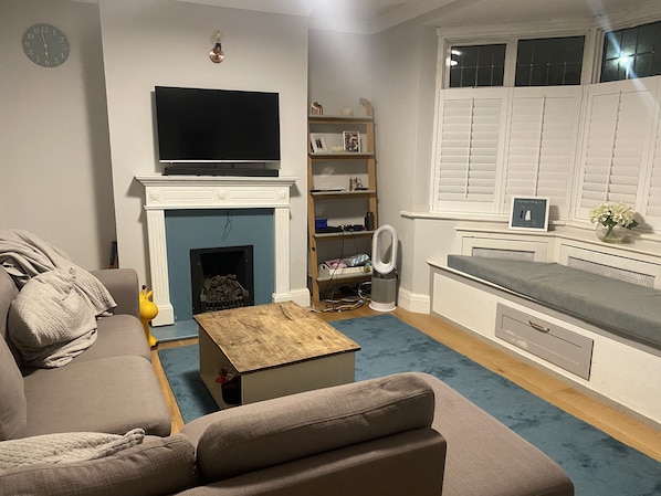 Cozy living space with a flat-screen TV, fireplace, and comfortable sofa.