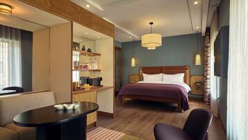 Ein Hotelzimmer mit Bett, Schreibtisch, Stuhl, Fernseher und Minibar.