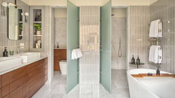 A modern bathroom with a large bathtub, a separate shower area, and a vanity with a mirror and shelves.