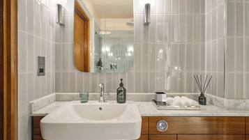 A bathroom with a large mirror, a sink, and a vanity with a wooden cabinet.