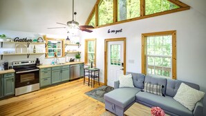 A spacious kitchen with wooden cabinets, a dining area with a table and chairs, and a cozy seating area with a sofa. - Visit #mytreetophideaway located in Banner Elk, NC, nestled high in the trees.  (Banner Elk)