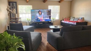 A living room with a television, sofas, a coffee table, and a bookshelf. - Luxurious Ranch at the heart of Round Rock (Round Rock)