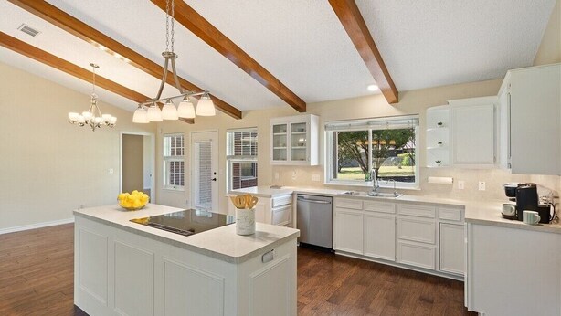 A modern kitchen with white cabinetry, a central island, and a large window providing a view of the outdoors. - Luxurious Ranch at the heart of Round Rock (Round Rock)