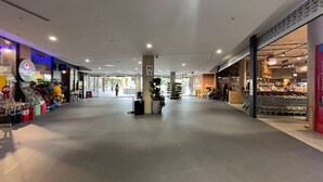 A spacious indoor shopping area with a central pillar, a variety of shops on either side, and a clear walkway. - Specious apartment in Kingston, centrally located place. (Kingston)