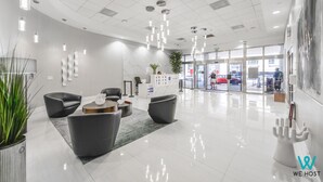 Een moderne lobby met een receptiebalie, een zithoek en een glazen entree.