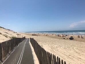 A beach with a wooden boardwalk leading to the shore.
