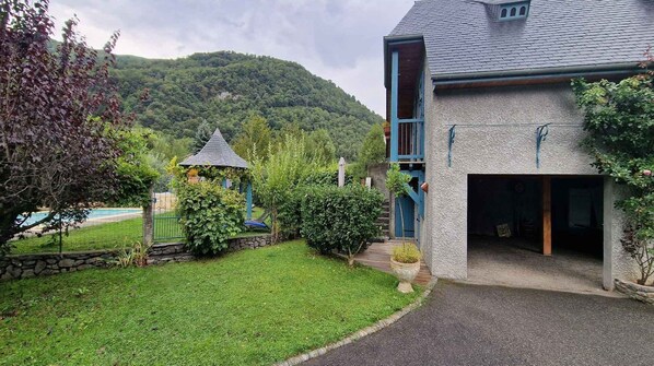 A house with a stone facade, a blue door, and a covered porch.