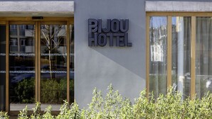 Une enseigne d’hôtel portant le nom « BIJOU HOTEL », apposée sur la façade d’un immeuble moderne.