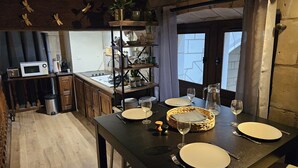 Eine gemütliche Küche mit Holzausstattung, einer Mikrowelle und einem Essbereich, der für eine Mahlzeit gedeckt ist.