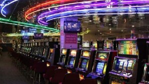 A row of slot machines in a dimly lit room with neon lights. - Cozy Remodeled House! (Port Richey)