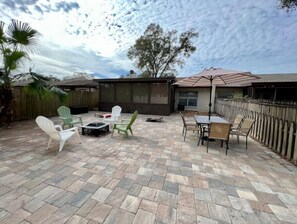 A patio with stone flooring, outdoor furniture, and a covered seating area.