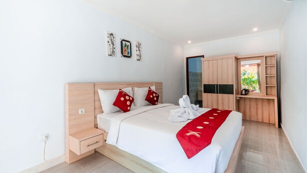 A modern bedroom with a wooden bed, a small bedside table, and a built-in wardrobe. - Kalpataru Cottage Nusa Penida (Penida Island)