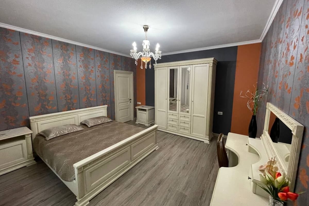 Ein Schlafzimmer mit einem großen Bett, einem Schminktisch mit Spiegel und einem Kleiderschrank.