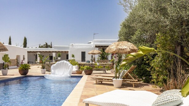 A pool area with lounge chairs, a thatched umbrella, and potted plants. - Boho-chic Villa in San Rafael 1min (Sant Antoni de Portmany)
