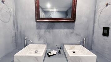 Un baño con dos lavamanos, un espejo y una pequeña bandeja con objetos.