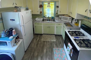 A compact kitchen with a refrigerator, microwave, stove, and sink. - Rochester Escape w/ Hot Tub & Fire Pit! (Rochester)