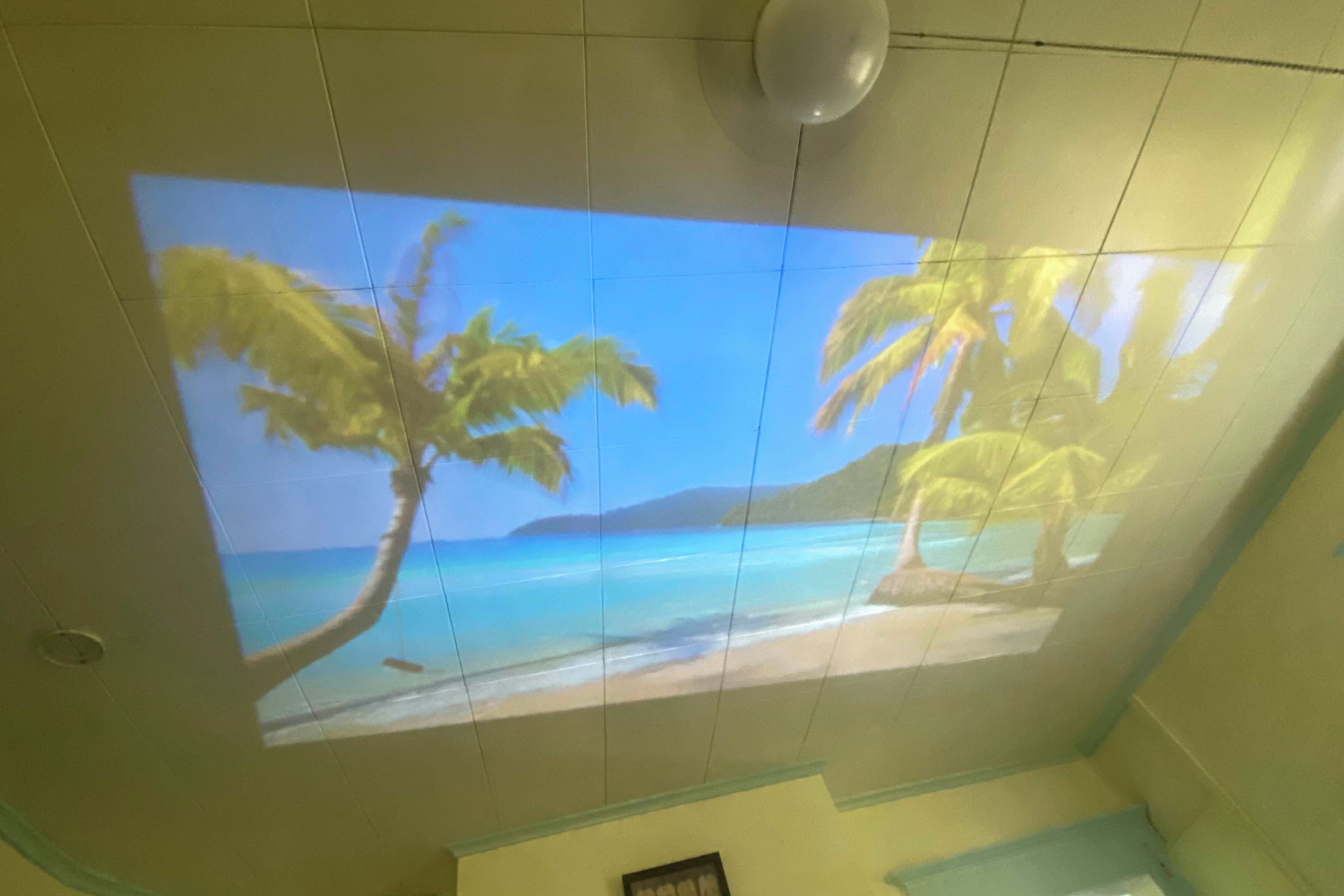 Techo con proyección de una escena de playa tropical.