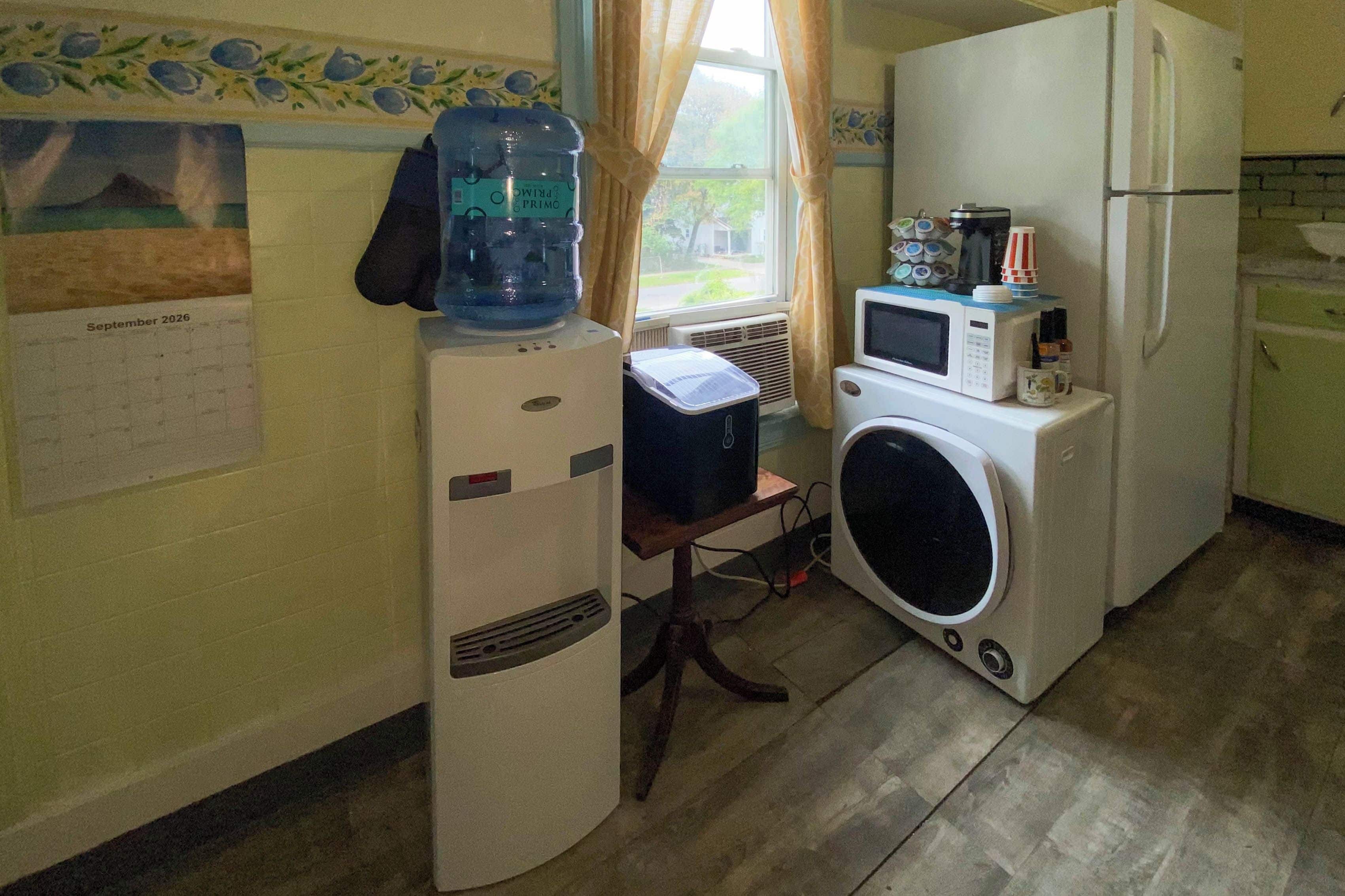 Cocina compacta con refrigerador, microondas y lavadora.