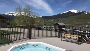 Un jacuzzi en una terraza con vista a la montaña.