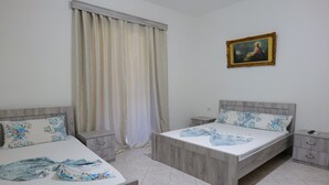 Un dormitorio con dos camas, una mesita de noche, un aparador y un cuadro en la pared.