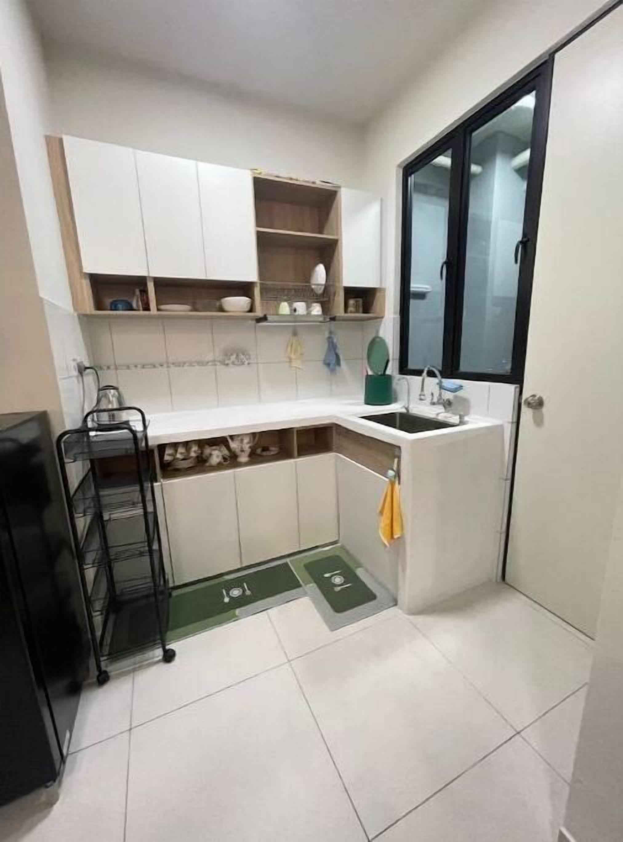 A compact kitchen with white cabinets, a sink, and a window.