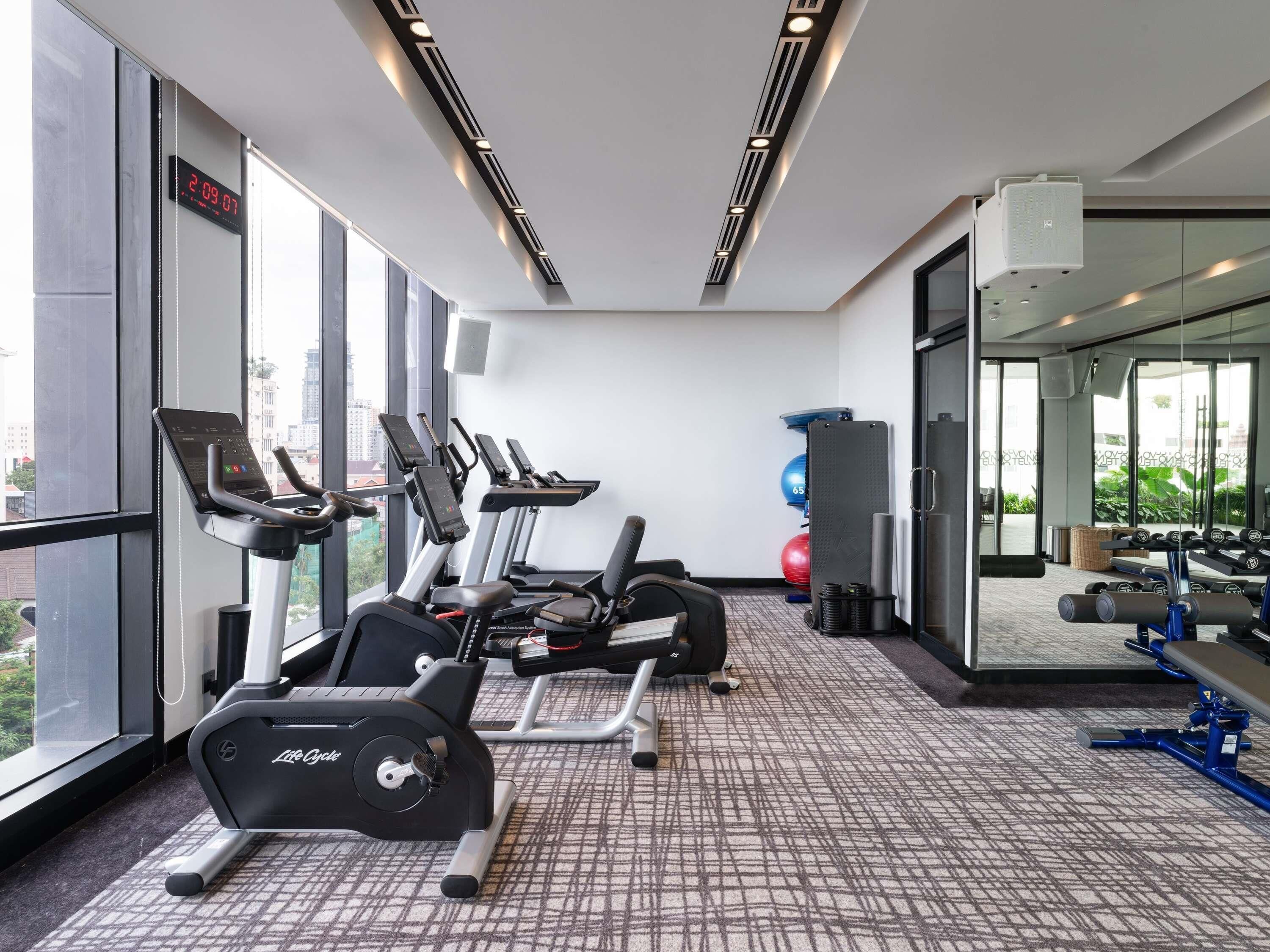 A gym with treadmills, a stationary bike, and exercise balls.