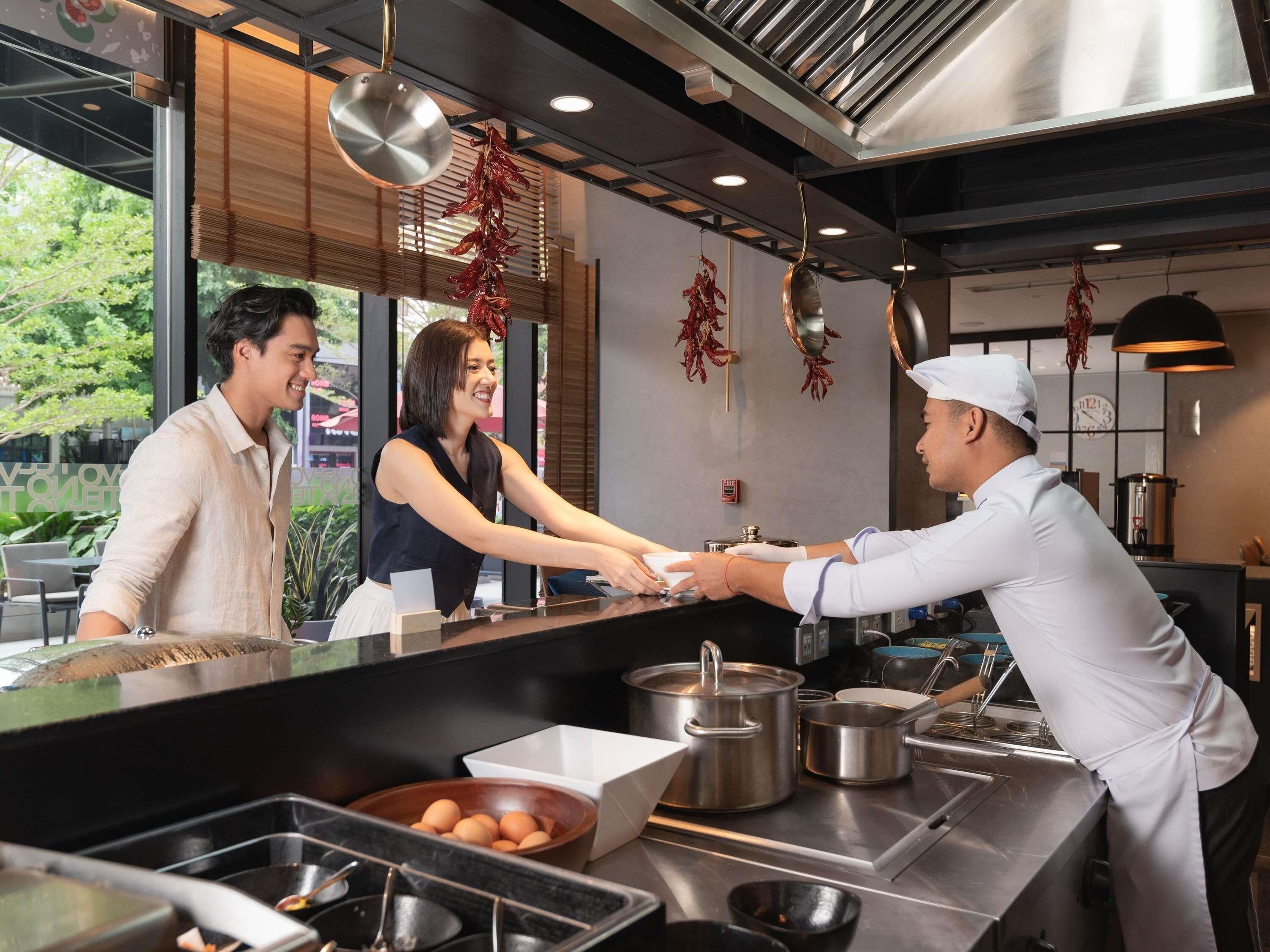 A restaurant interior with a counter, cooking equipment, and hanging decorations.
