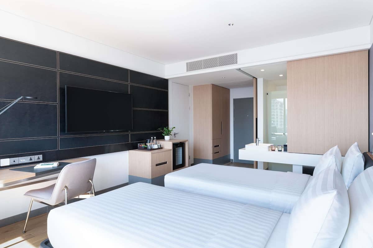 Ein modernes Hotelzimmer mit Bett, Schreibtisch, Fernseher und Badezimmer.