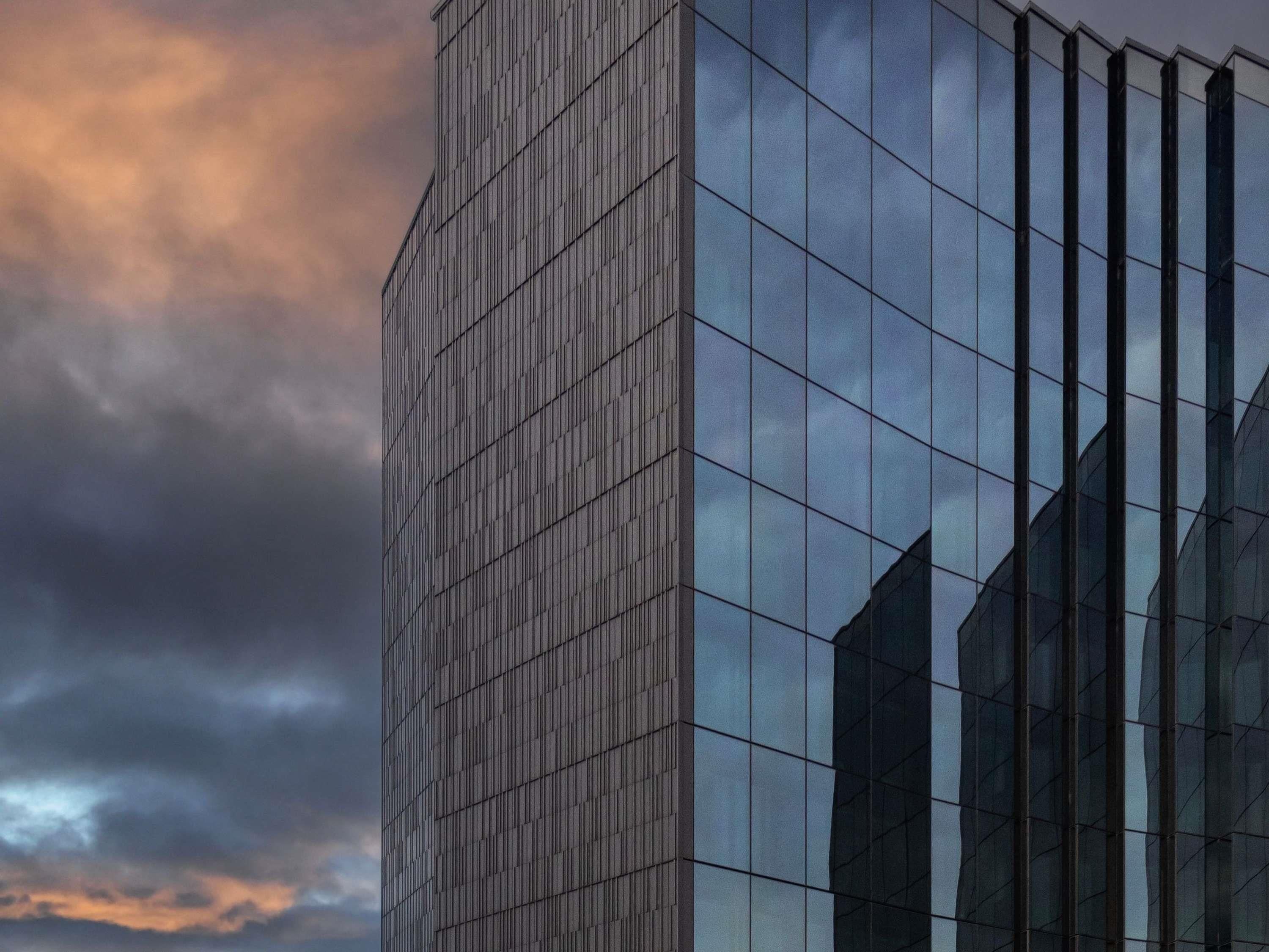 Un edificio moderno con fachada de entramado y ventanas de vidrio reflectante.