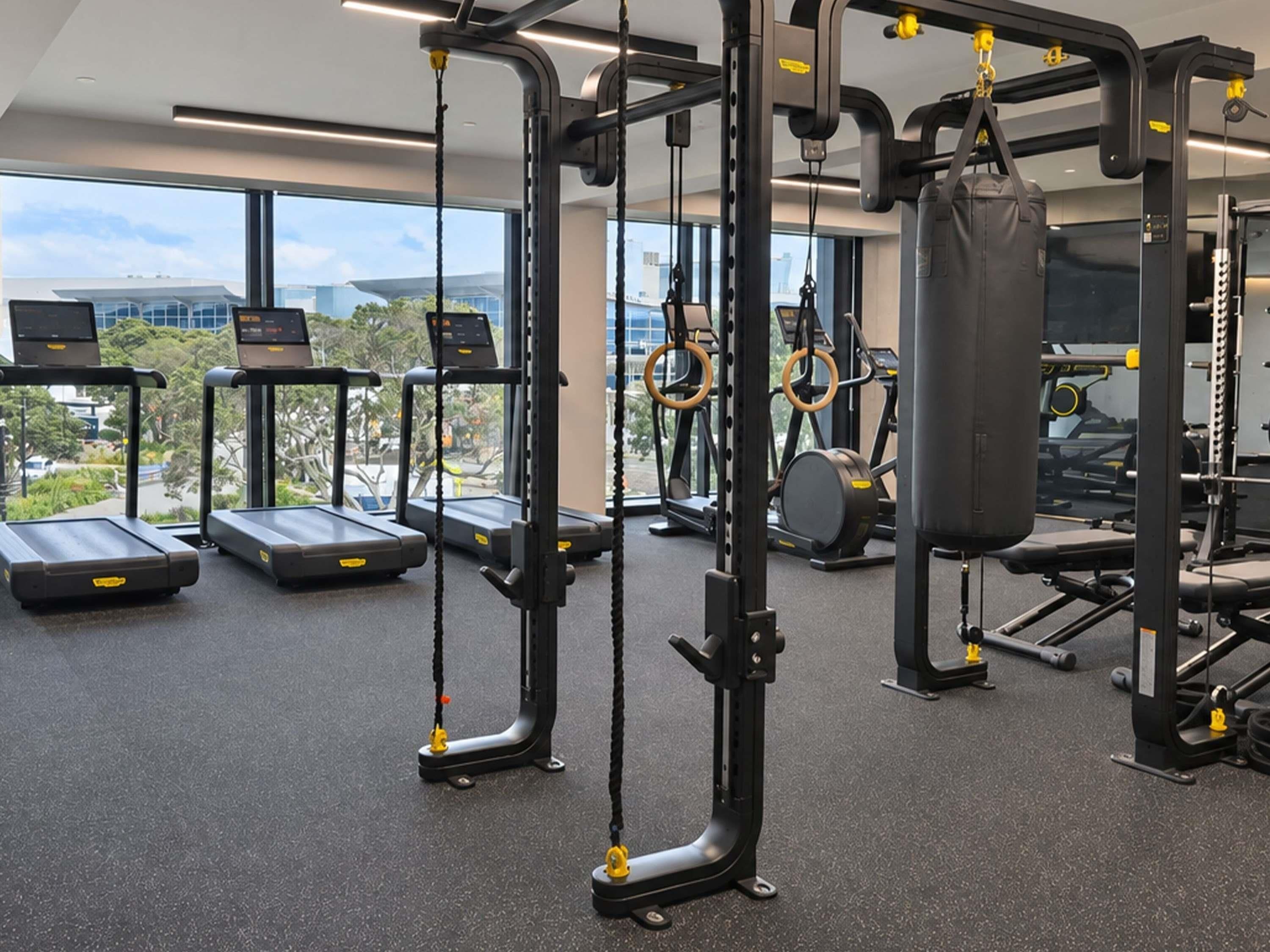 A gym with treadmills, a weightlifting station, and a punching bag.