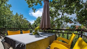 An outdoor dining area with a table set for two, yellow chairs, and a tablecloth. - Holiday apartment close to the center (Njivice)