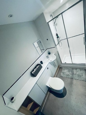 A modern bathroom with a shower, toilet, and sink. - Stunning 2-bed Apartment in Crawley (Crawley)