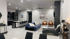 A modern living space with a kitchen, dining area, and seating area.