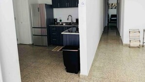 A compact kitchen with dark cabinets, a stainless steel refrigerator, and a sink. - La Casa Blanca 1 (Carolina)