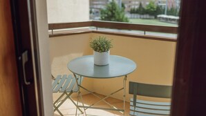 A balcony with a small round table and a potted plant. - Bright Apartment by Homing (Porto)