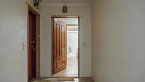 A hallway with a wooden door leading to a balcony. - Bright Apartment by Homing (Porto)